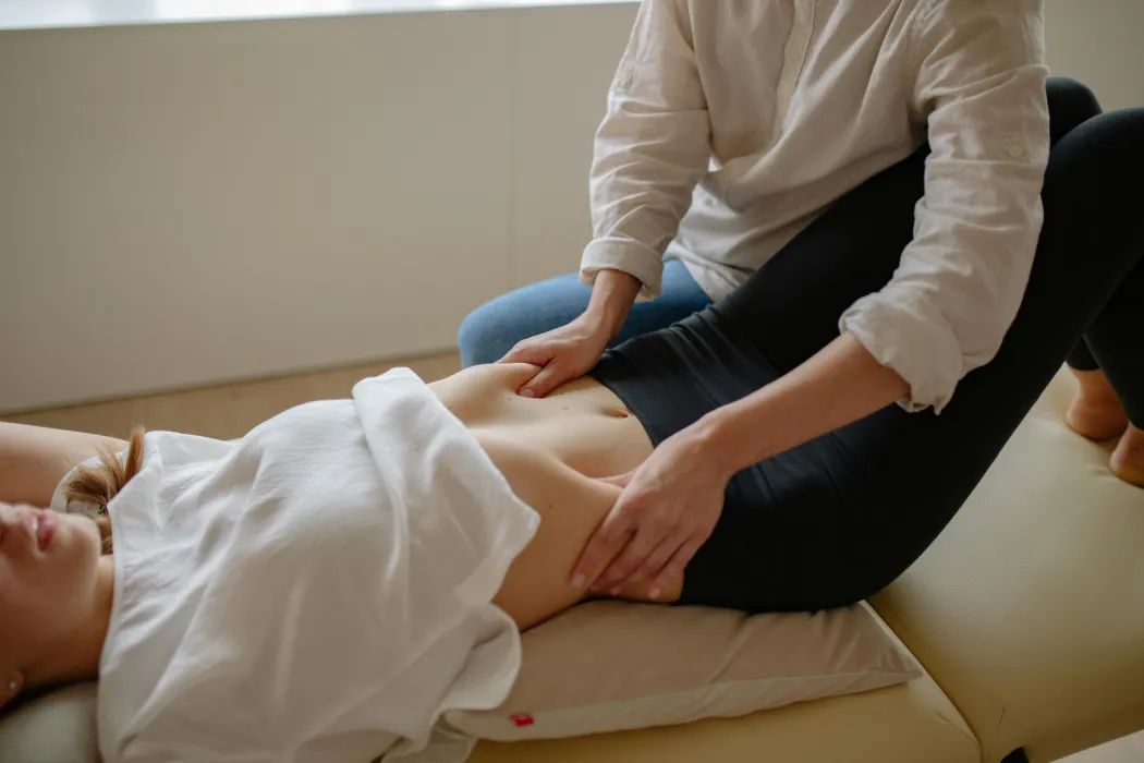 Ostéopathe traitant les maux de ventre d'un patient par des techniques viscérales